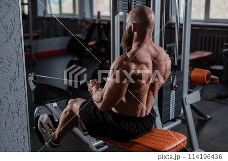Caucasian man doing rowing exercises on a rowing machine. Caucasian man doing rowing exercises on a rowing machine. 114196436