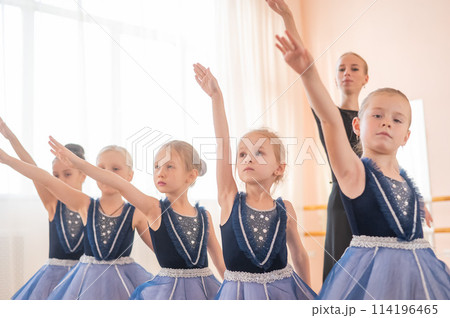 Children's ballet school. Caucasian woman teaching ballet to little girls.  114196465
