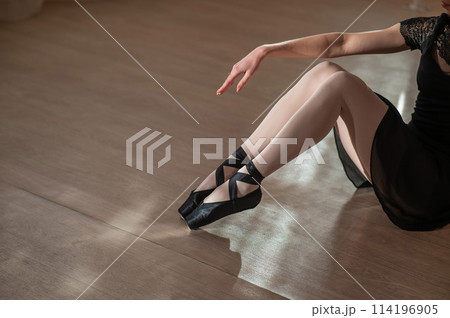 Close-up of the legs of a ballerina sitting on the floor. Close-up of the legs of a ballerina sitting on the floor. 114196905