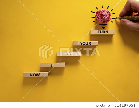 Business concept growth success process. Wood blocks stacking as step stair on yellow background, copy space. Businessman hand. Words 'now, it is your turn'. Conceptual image of motivation. 114197951