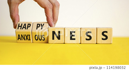Happyness or anxiousness. Doctor turns cubes and changes the word 'anxiousness' to 'happyness'. Beautiful yellow table, white background. Psychological, happyness or anxiousness concept. Copy space. Happyness or anxiousness. Doctor turns cubes and changes the word 'anxiousness' to 'happyness'. Beautiful yellow table, white background. Psychological, happyness or anxiousness concept. Copy space. 114198032