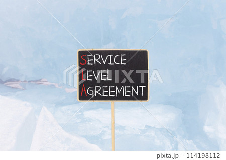 SLA service level agreement symbol. Concept words SLA service level agreement on beautiful yellow blackboard. Beautiful blue ice background. Business SLA service level agreement concept. Copy space. 114198112