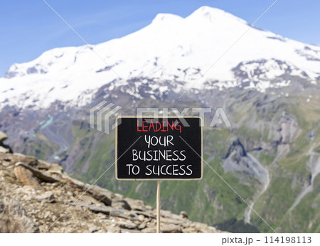 Leading business to success symbol. Concept words Leading your business to success on beautiful blackboard. Beautiful mountain Elbrus background. Leading your business to success concept Copy space 114198113