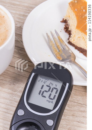 Glucometer with high result sugar level, portion of sweet cheesecake and cup of coffee with milk Glucometer with high result sugar level, portion of sweet cheesecake and cup of coffee with milk 114198336