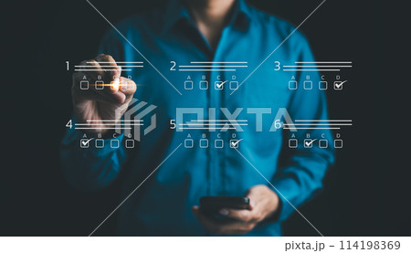 Businessman makes selections on a digital checklist. assessment online, choose correct answer in test, questions test, online exam, quiz knowledge, task management, filling out survey form. e-learning 114198369