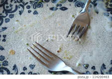 An empty dirty plate with a fork. 114200463
