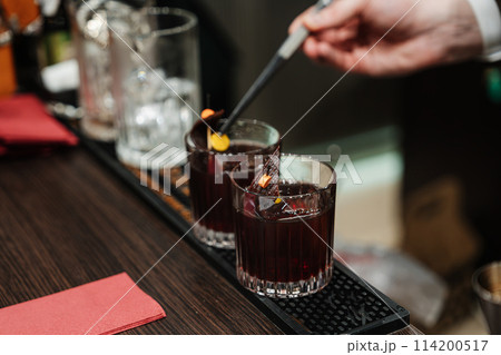 The bartender prepares cocktails for the client. 114200517
