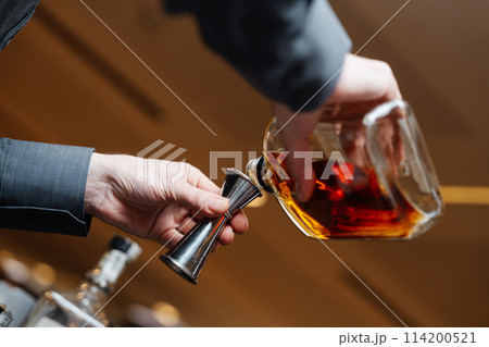Bartender pours whiskey for tasting. 114200521
