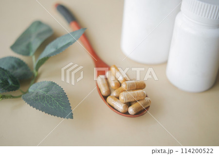 herbal medicine capsule on a wooden spoon  114200522