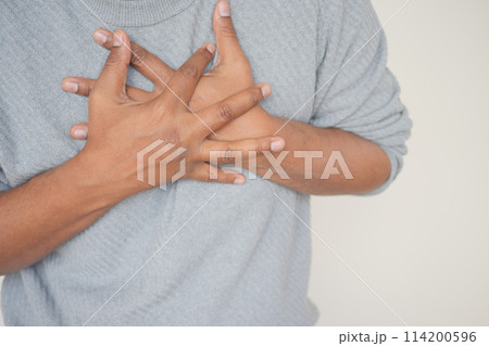 young man suffering pain in heart and holding chest with hand  114200596