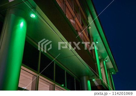 Green Illuminated Modern Building in Night Time Urban Landscape 114201069