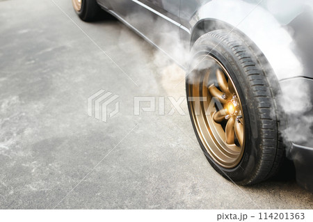 Racing car with golden wheels parked on the cement road and smoke coming from the brake system 114201363