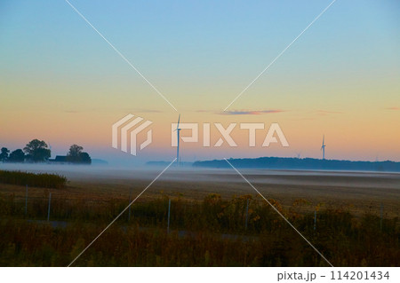 Misty Dawn over Harvested Farmland with Wind Turbines Misty Dawn over Harvested Farmland with Wind Turbines 114201434