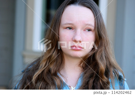 Horizontal portrait of a young blond girl with trendy make-up and hairstyle. Teenager with big blue eyes and brightly tinted lips 114202462