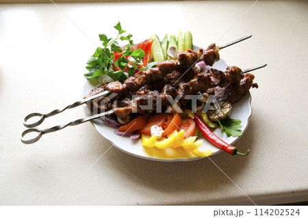 Shish kebab with mushrooms, cherry tomato and sweet pepper, Grilled meat skewers. Top view, copyspace. most important meat dish of Turkish cuisine kebabs is a rich product that is cooked on embers 114202524