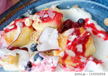 Cottage cheese pancakes, Syrniki or Cheesecakes with dried pineapple and caramel isolated on black marble background. Homemade food. Tasty breakfast. Selective focus. Cottage cheese pancakes, Syrniki or Cheesecakes with dried pineapple and caramel isolated on black marble background. Homemade food. Tasty breakfast. Selective focus. 114202858