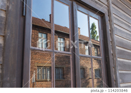 【ポーランド】アウシュビッツ・ビルケナウ強制収容所内の木造の建物の窓に反射して映るレンガ造りの建物 【ポーランド】アウシュビッツ・ビルケナウ強制収容所内の木造の建物の窓に反射して映るレンガ造りの建物 114203846