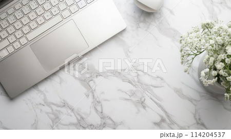 Notebook with keyboard with flowers in vase on white marble table. Top view Notebook with keyboard with flowers in vase on white marble table. Top view 114204537