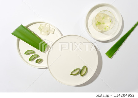 Top view photo with blank round dish placed in center for displaying products which made from aloe vera. Blank space for designing or advertising Top view photo with blank round dish placed in center for displaying products which made from aloe vera. Blank space for designing or advertising 114204952