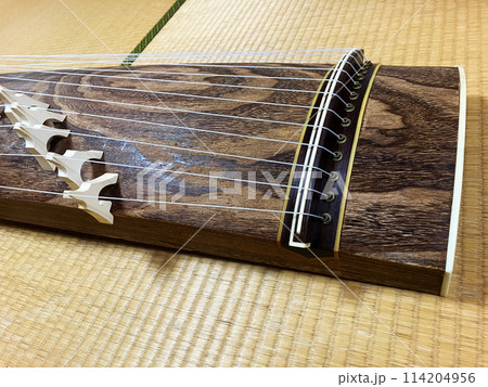 日本の和室の畳の上に伝統的な13本の弦楽器である箏がある。枕部分のアップ 114204956