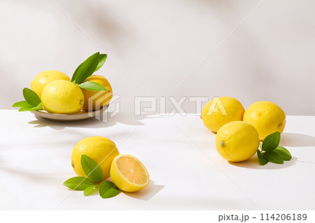 Fresh yellow lemons neatly arranged on white table with blank space for displaying product of natural ingredient. Front view photo for advertising or designing Fresh yellow lemons neatly arranged on white table with blank space for displaying product of natural ingredient. Front view photo for advertising or designing 114206189
