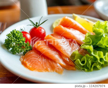 白い皿に盛り付けたスモークサーモンとレモン 白い皿に盛り付けたスモークサーモンとレモン 114207974