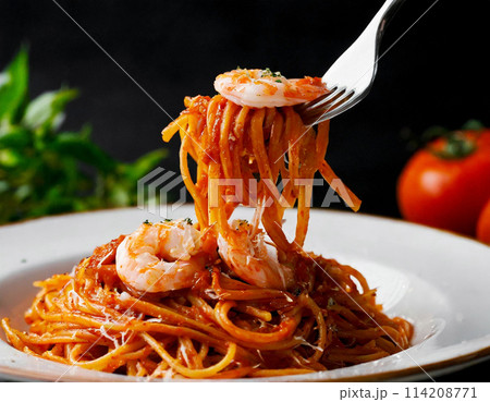 フォークで持ち上げたトマトとシーフードのパスタ 黒背景 フォークで持ち上げたトマトとシーフードのパスタ 黒背景 114208771