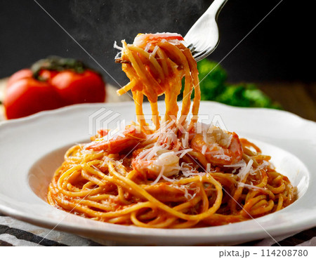 フォークで持ち上げたトマトとシーフードのパスタ　黒背景 114208780