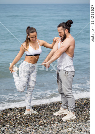 Couple stretching on beach 114211627