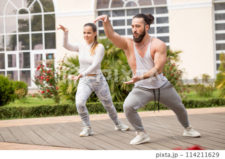 Karate group making shot show-performance on a squre before fitness centre 114211629