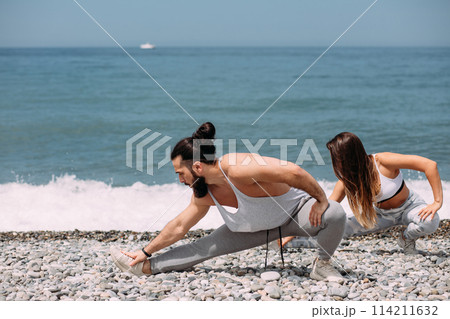 Stretching before everyday jogging on the beach 114211632