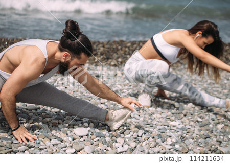 Stretching before everyday jogging on the beach 114211634