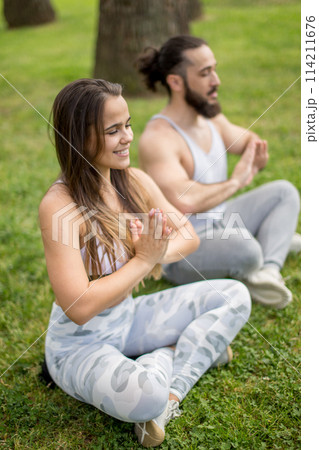 Young couple doing yoga outdoors 114211676