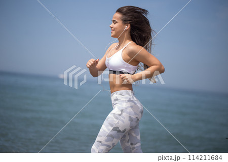Woman training yoga on the beach at sunset 114211684