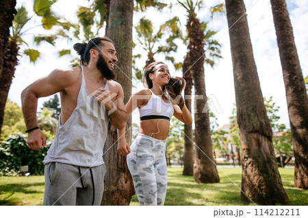 Young couple running in park in summer morning Young couple running in park in summer morning 114212211