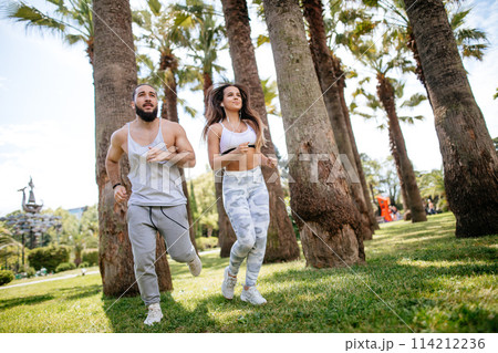 Young couple running in park in summer morning Young couple running in park in summer morning 114212236
