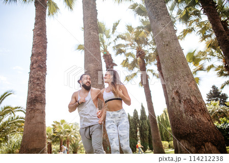 Young couple running in park in summer morning Young couple running in park in summer morning 114212238