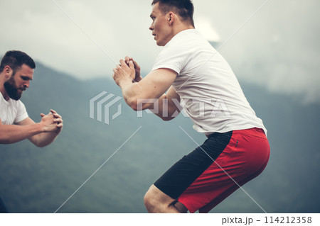 Two male athletic friends doing box jump exercise outdoor Two male athletic friends doing box jump exercise outdoor 114212358