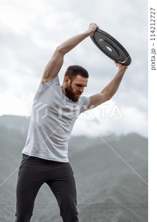 Handsome muscular hunk man looking at mountains from the peak. Handsome muscular hunk man looking at mountains from the peak. 114212727