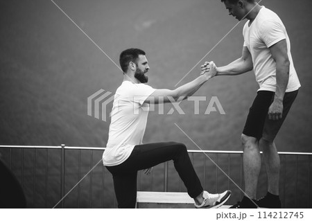 Two athletes rest after intense outdoor workout training in mountain landscape 114212745
