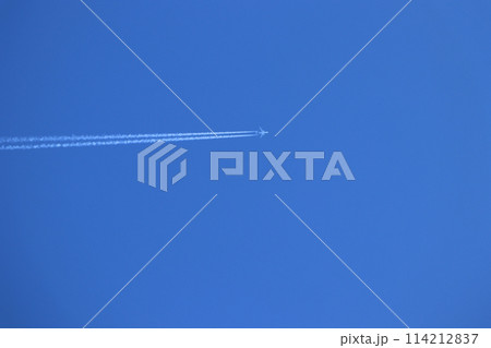 青空を飛行機雲を引きながら紺碧の青空に白く輝く 114212837