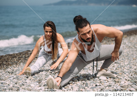 Stretching before everyday jogging on the beach 114213407