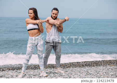 Couple stretching on beach Couple stretching on beach 114213479
