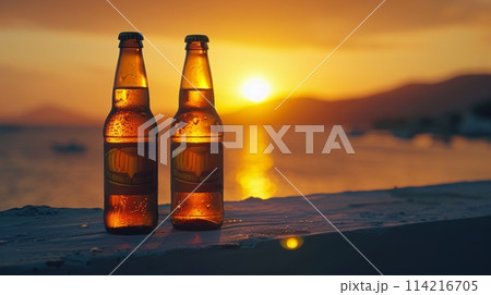 Two bottles of beer on a balcony ledge, soaking up the warm light of a sunset 114216705