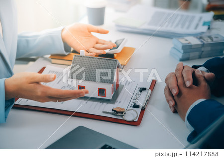 Real estate agent talked about the terms of the home purchase agreement and asked the customer to sign the documents to make the contract legally, Home sales and home insurance concept. 114217888