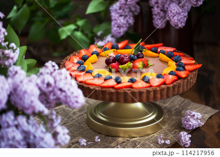 Delicious homemade chocolate tart decorated with fresh strawberry, blueberry, apricot and cherry Delicious homemade chocolate tart decorated with fresh strawberry, blueberry, apricot and cherry 114217956