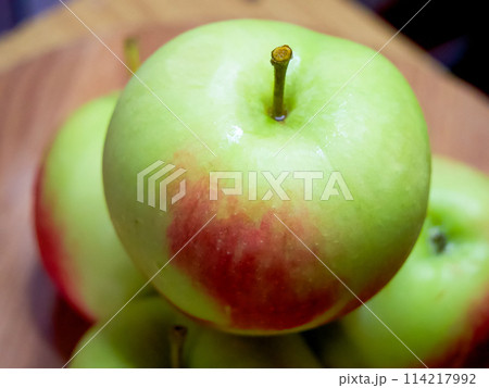 Fresh Green Apples. Crisp apples with a red blush on a wooden table. 114217992