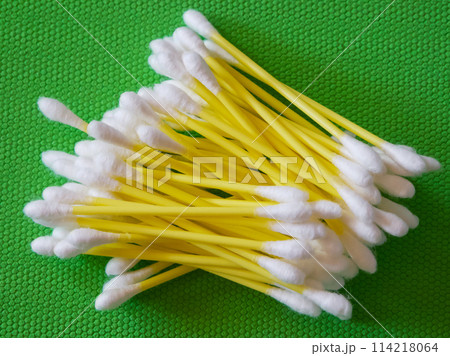 Cotton Swab Array. White-tipped swabs with yellow stems, green backdrop. Cotton Swab Array. White-tipped swabs with yellow stems, green backdrop. 114218064