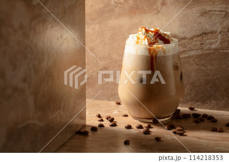 Iced caramel latte topped with whipped cream and caramel sauce. Iced caramel latte topped with whipped cream and caramel sauce. 114218353