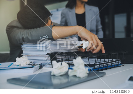 Stressful business man have so many paperwork in the office 114218869
